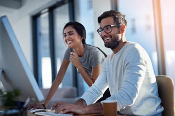 Share what makes you happy. Shot of two young coworkers using a 